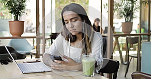 Serious young woman working at a laptop