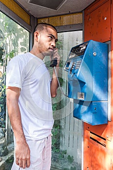 Seriously asian man using payphone