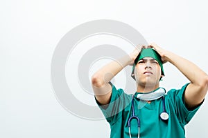 Seriously asian young doctor male hands on forehead disappointed treatment for patient .Doctor surgery in green uniform  with