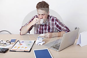 Seriously businessman drinking a coffee in working space at office. Busy business