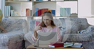 Seriously Young mother while working at home with two daughters