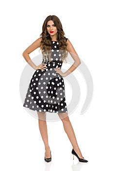 Seroius Beautiful Young Woman Is Posing In Black Cocktail Dress In Polka Dots And High Heels