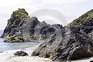 Serpentine rock cliffs at the tide edge at Kyance Cove in Cornwall