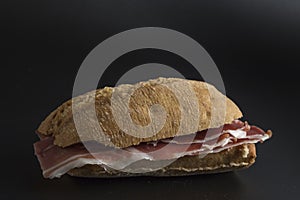 Serrano ham sandwich isolated on black background