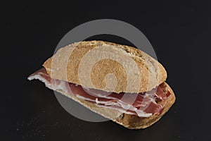 Serrano ham sandwich isolated on black background