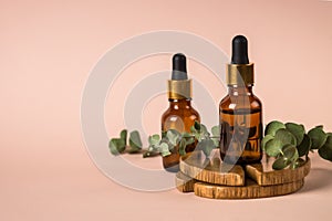 Serum bottle with fresh leaves at pastel background.