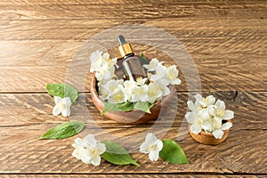 a serum for the care of the skin of the face and body based on jasmine oil lies in a wooden bowl among white flowers