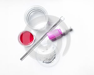 Serum, Cetyl Esters Wax, Red EPOXY liquid rasin and alcohol. Chemicals for beauty care placed next to the stirring rod on white