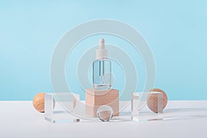 Serum cosmetic bottle with peptides and retinol on acrylic and wooden blocks on pink background. Oil cosmetics