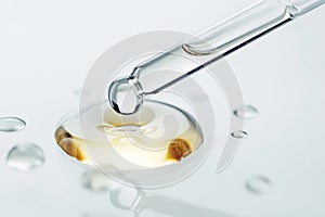 Serum dropper and skin care cosmetics product drop close-up on white background