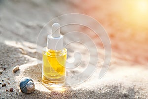 Serum oil and snail close-up on textured natural sand