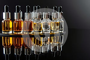 serums in glass droppers on reflective black base photo