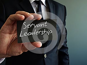 Servant leadership concept. Black piece of paper in the hand