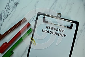 Servant Leadership write on paperwork isolated on Wooden Table