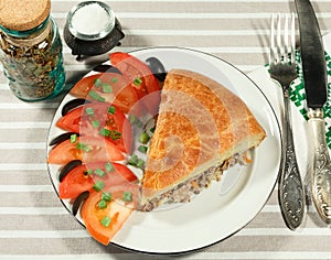 Serve fish pie with slices of tomatoes, green onions and olives