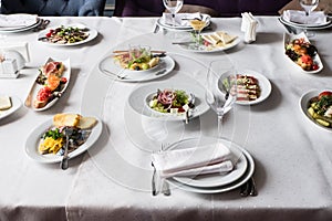 Served for banquet restaurant table with dishes, snack, cutlery, glasses