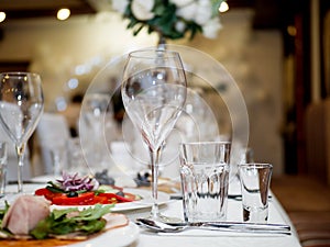 Served for a banquet table. Wine glasses with napkins, glasses and salads.