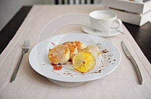 Served breakfast in the restaurant. Cottage cheese pancakes with orange ringlets and coffee