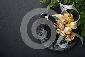 Served christmas table setting empty black ceramic plate on dark background Christmas Decoration. Holiday Decorations with gold