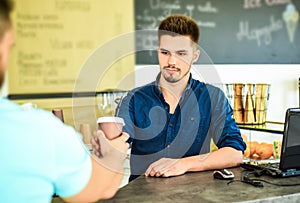 Served coffee to go. Barista at bar of modern cafe ready serve coffee for client. Barista handsome stylish hipster