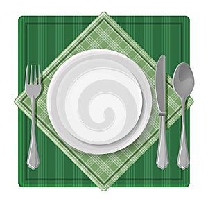 Served dinner plate with cutlery spoon fork and knife on green