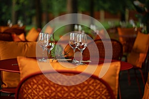 Served dinner table with four empty wine glasses in restaurant terrace in pine wood.