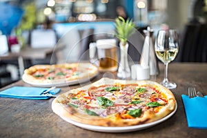 The served dinner table with pizza in pizzeria or restaurant