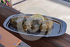 Served dolmades, wrapped in little rolls, a traditional dish with stuffed vine leaves, served with a slice of lemon