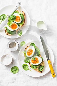 Served Easter brunch plate - grilled bread sandwich with spinach and boiled eggs on white background