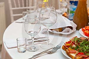 Served for holiday banquet restaurant table with dishes, snack, cutlery, wine and water glasses