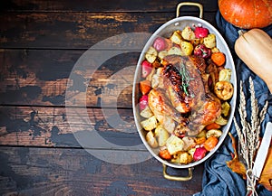 Served roasted Thanksgiving Turkey with vegetables on brown wooden rustic background.