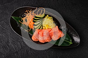 Served salmon sashimi  on black background