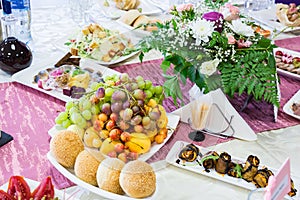 Served table at the Banquet. Fruits, snacks, delicacies and flowers in the restaurant. Solemn event or wedding