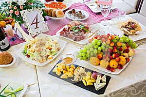 Served table at the Banquet. Fruits, snacks, delicacies and flowers in the restaurant. Solemn event or wedding