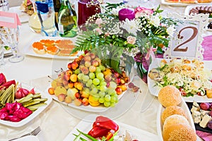 Served table at the Banquet. Fruits, snacks, delicacies and flowers in the restaurant. Solemn event or wedding