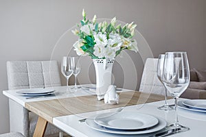 Served table with a bouquet of roses in interior of modern luxure guest room in studio apartments in minimalistic style photo