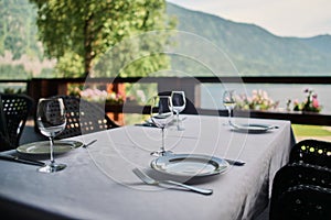 served table with burning candles and fresh flowers for a festive dinner.