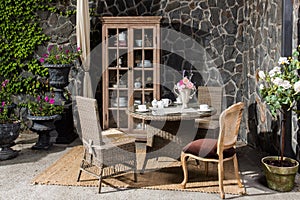 a served table and chairs made of rattan furniture on the veranda