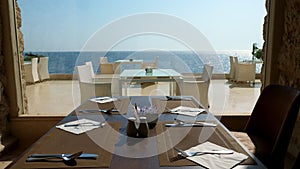 Served table in the restaurant by a large panoramic window overlooking the sea.