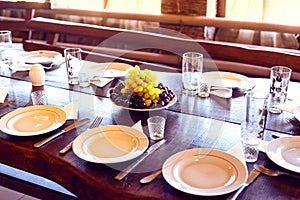 Served table in the restaurant, plates, forks, knives, glasses. in the center of the ripe grapes