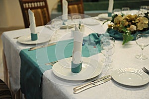 Served table in the restaurant with turquoise tablecloth