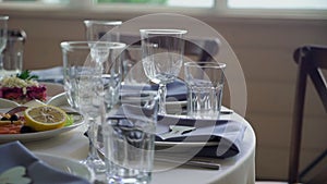 Served tables for a holiday in a restaurant. Glasses, plates, cutlery, napkins.