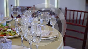 Served tables for a holiday in a restaurant. Glasses, plates, cutlery, napkins.