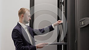 Server engineer working in data center room using laptop