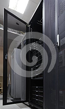 Server rack in big data center inside close up. Supercomputer with hardware, storage blades, cables and wires