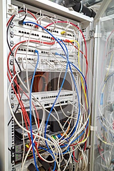 in a server rack many different colored network cables are connected to the network switches