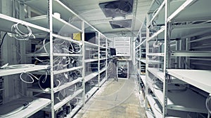 Server room for crypto currency mining. Row of bitcoin miners set up on the wired shelfs. Mining cryptocurrency. Bitcoin