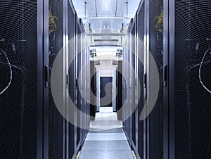 Server room data center network for virtual hosting services. Corridor inside with racks of supercomputers mainframe and high