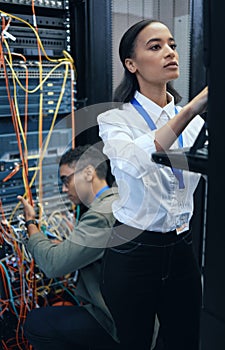 Server room, engineer or IT team working together for programming, cybersecurity or maintenance. African woman and man