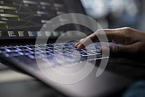 Server room programmer coding on laptop, typing on keyboard, close up